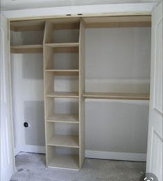 an empty walk in closet with shelves and carpeted flooring on the side wall