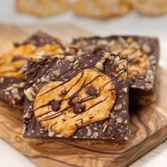 three pieces of chocolate peanut butter pretzels on a wooden cutting board