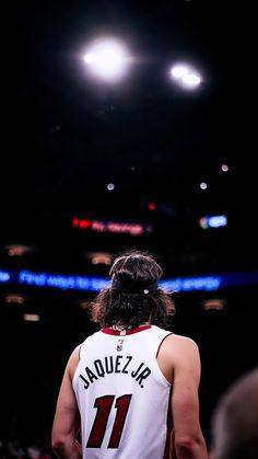 the back of a basketball player's jersey in front of an arena full of people