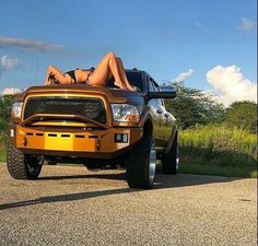 a woman laying on the hood of a truck