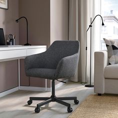 a white desk chair sitting in front of a window