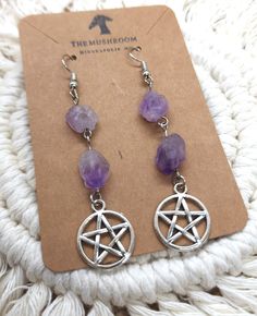 A pentagram's five sides represent the five elements of air, fire, water, earth, and spirit. Amethyst symbolizes peace and unification.  Cute and lightweight. Faux amethyst stones. Measurements: Drop length is 2.5 inches. Pentagram charm is approximately .75 inch.  Hypoallergenic, nickel-free posts, hoops, and hooks are used on all pieces. Silicone backs are included. These earrings may not be suitable for sensitive skin. Buying a gift for someone special? We offer gift wrapping! Depending on the size and number of items purchased, your gift will be packaged in The Mushroom's signature brown kraft box, wrapped in a beautiful gift paper, or a decorative drawstring bag with white paper tissue. A matching brown kraft mini card will be included for your personalized message, stamped with a spe Gothic Star-shaped Jewelry For Festivals, Mystical Metal Earrings For Festivals, Spirit Amethyst, Magical Elements, Earth Air Fire Water, Bead Ornaments, Elements Earth, Water Spirit, Air Fire