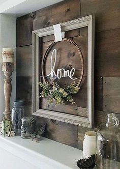 a wooden sign hanging on the side of a wall next to candles and vases