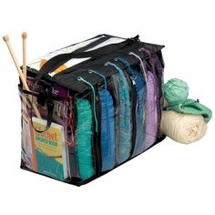 several skeins of yarn and knitting needles in a storage bag on a white background