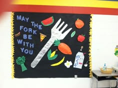 a classroom wall with a fork and vegetables on it