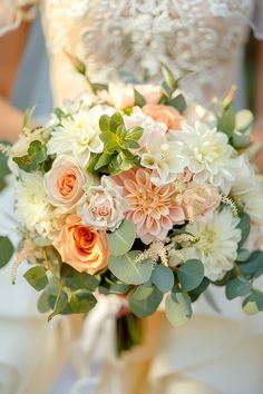 a bridal bouquet with peach and white flowers