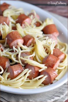 a white plate topped with spaghetti and hot dogs