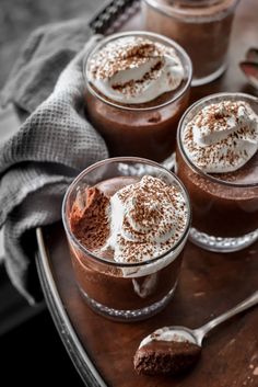 three glasses filled with chocolate pudding and whipped cream