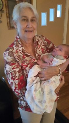 an older woman holding a baby in her arms