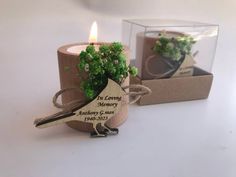 two small candles sitting next to each other on top of a white table with a box