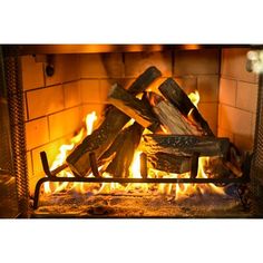 a fire burning in a fireplace with logs