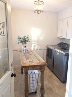 a small kitchen with a table in the middle and a washer and dryer on the other side