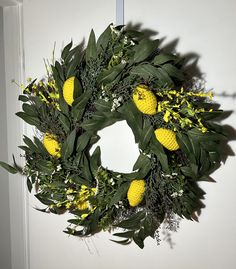 a wreath with yellow flowers and green leaves