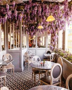 the interior of a restaurant with wistery vines hanging from the ceiling and tables