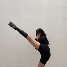 a woman in black is doing a kickbox pose