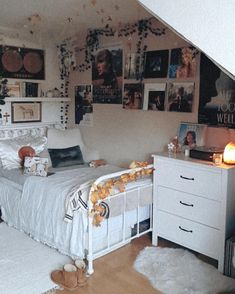 a bedroom with pictures on the wall and white bedding, rugs and drawers