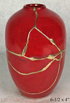 a red vase with gold lines on it