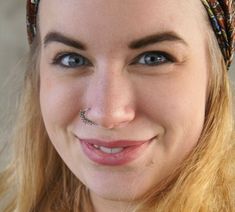 a close up of a person wearing a bandana with a smile on her face