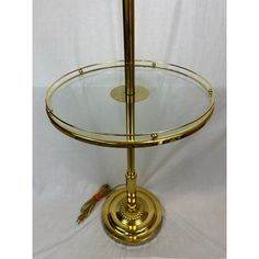 a glass and brass plate stand on a white background