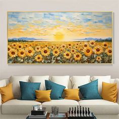 a living room with a couch, coffee table and large sunflower painting on the wall