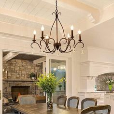 a dining room table with chairs and a chandelier hanging from it's ceiling