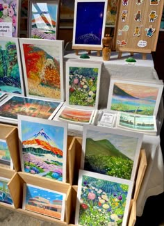 many paintings are on display at an outdoor market