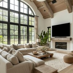 a living room filled with furniture and a flat screen tv mounted on the wall above a fireplace