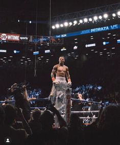 a man standing on top of a wrestling ring