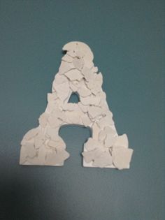 the letter a is made out of small pieces of white paper on a blue surface