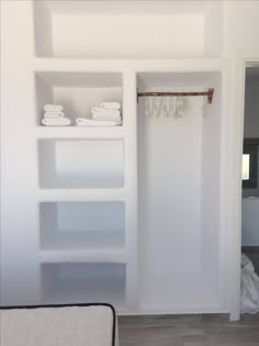 a white closet with shelves and towels on it