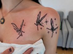 a woman's shoulder with three fairy tattoos on it