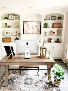 a desk with a computer on top of it in front of some bookshelves