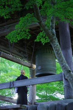 a man standing next to a large bell