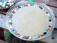 two bowls filled with different colored rocks sitting on top of a wooden table next to each other