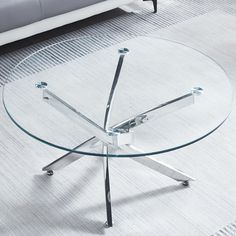 a glass coffee table with chrome legs and wheels