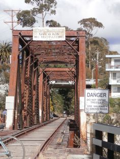 an old rusted bridge with no trestles and a bicycle parked on the side