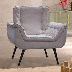 a gray chair sitting on top of a white rug