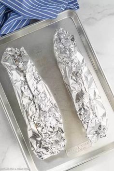 two pieces of aluminum foil sitting on top of a pan