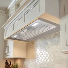 a stove top oven sitting inside of a kitchen next to white cabinets and counter tops