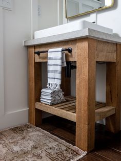 a bathroom with a sink, towel rack and rug on the floor in front of it