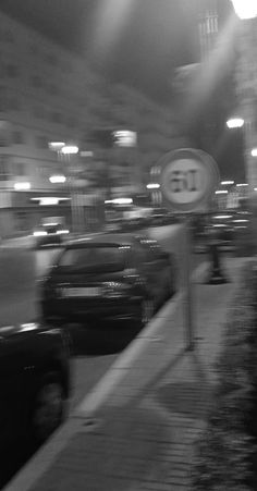 a blurry photo of cars parked on the side of a city street at night