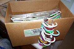 an open cardboard box filled with lots of different colored cords and scissors on top of a table