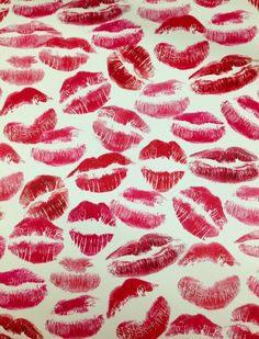 lipstick kisses drawn on a white surface with pink and red colors, all over it