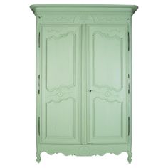 a green armoire with ornate carvings on the top and bottom, against a white background