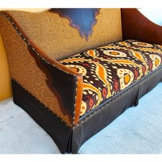 an upholstered couch with leather trimmings on the back and seat cushions