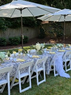 an outdoor table set up with blue and white linens for a formal dinner party