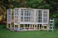 a house being built in the middle of a yard with windows on each side and doors open