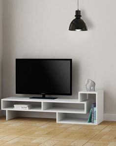 a flat screen tv sitting on top of a wooden entertainment center next to a lamp