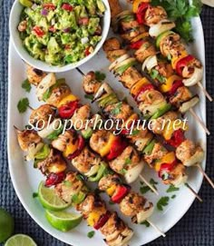 chicken kabobs on skewers with guacamole and salsa