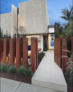 the entrance to a modern home with wooden fence